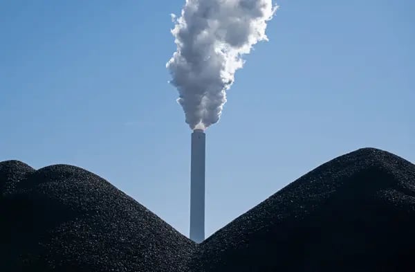 Una chimenea detras de pilas de carbón en Bremen, Alemania