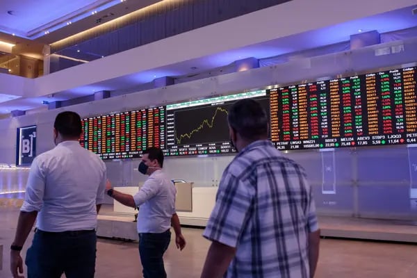 Visitors pass an electronic board displaying stock activity at the Brasil Bolsa Balcao (B3) stock exchange in Sao Paulo, Brazil, on Monday, Nov. 8, 2021. The Ibovespa opened 0.2 percent lower at 104,627.30 in Sao Paulo, with Brasil Bolsa Balcao contributing the most to the index decline, decreasing 1.9 percent. Photographer: Patricia Monteiro/Bloomberg