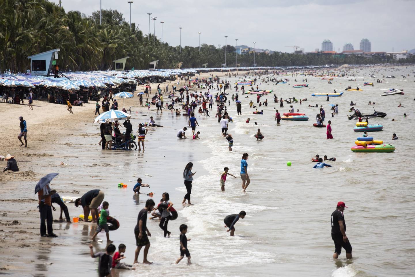 Visitantes se relajan en la playa y en el mar en la playa de Bangsaen en Chonburi, Tailandia, el domingo 14 de junio de 2020.
