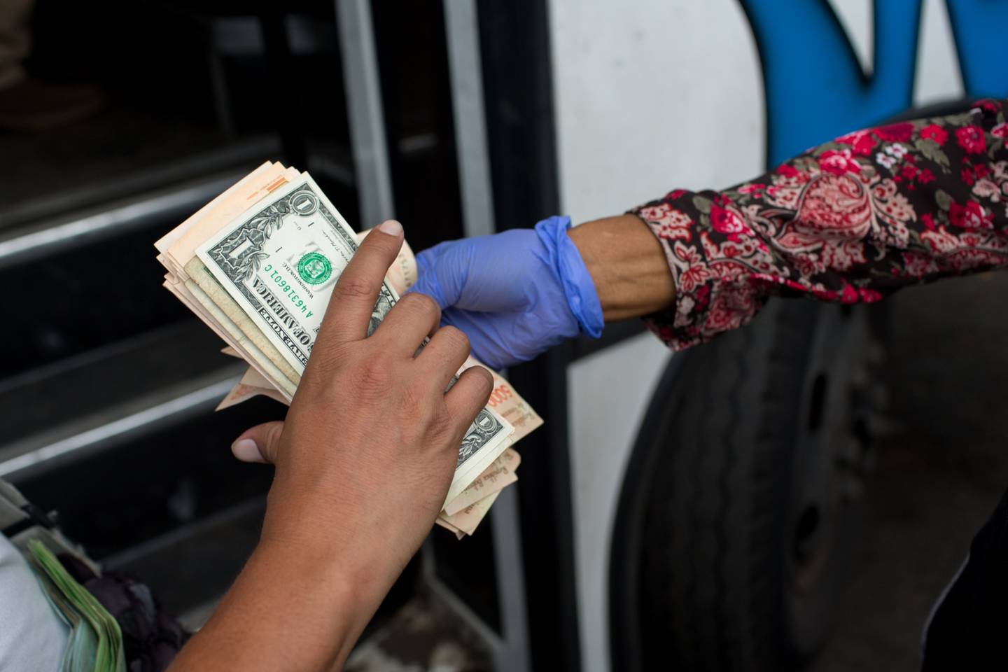 Un trabajador de un autobús sostiene billetes de dólares estadounidenses y bolívares venezolanos en una parada de autobús en Caracas, Venezuela,
.dfd