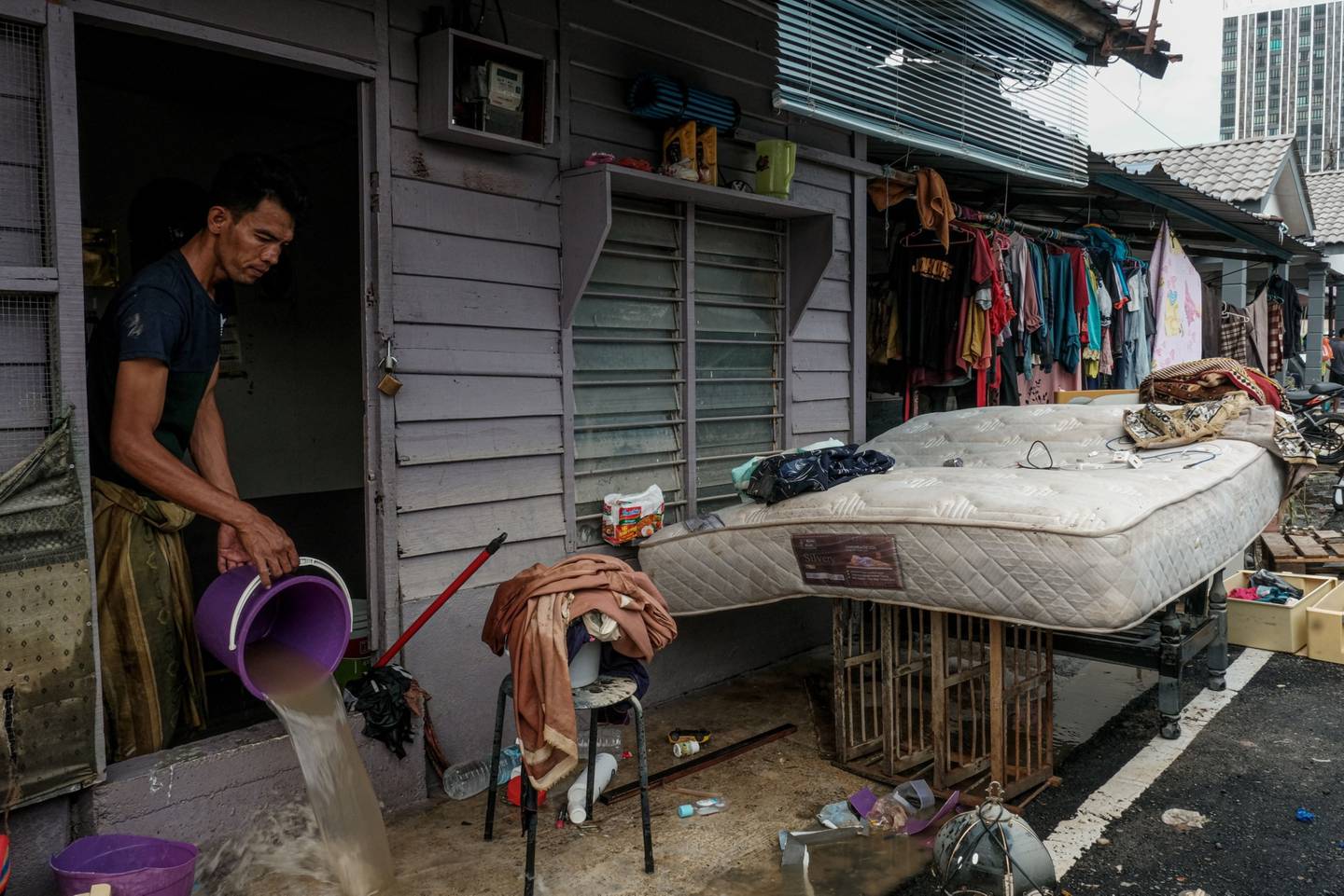 A resident bails out flood water from a home in Padang Jawa, Selangor, Malaysia, Dec. 20, 2021.  Photographer: Samsul Said/Bloombergdfd