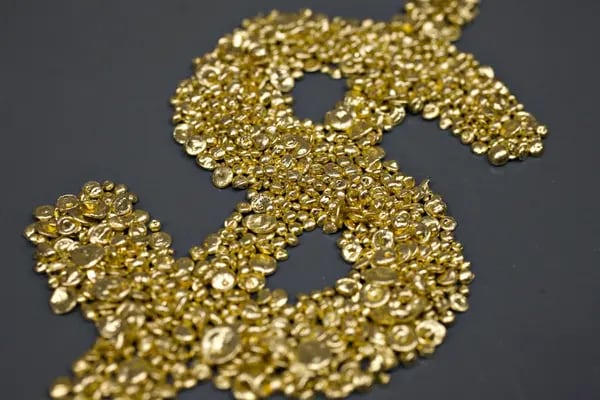 Grano de oro puro fundido se dispone en forma de símbolo de dólar en Dvir & Stoler Refining en Nueva York, Estados Unidos, el lunes 4 de enero de 2010.  Fotógrafo: Bloomberg/Bloomberg