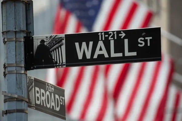 Un cartel de Wall Street frente a la Bolsa de Nueva York (NYSE) en Nueva York, EE.UU., el viernes 31 de diciembre de 2021. Las acciones estadounidenses oscilaron entre las ganancias y las pérdidas, con movimientos exacerbados por la escasa negociación en la última sesión del año. Fotógrafo: Michael Nagle/Bloomberg