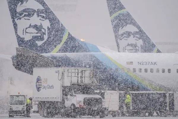 Trabajador junto a los aviones de Alaska Airlines durante una tormenta de nieve en el Aeropuerto Internacional de Seattle-Tacoma (SEA) en Seattle, Washington, EE.UU.