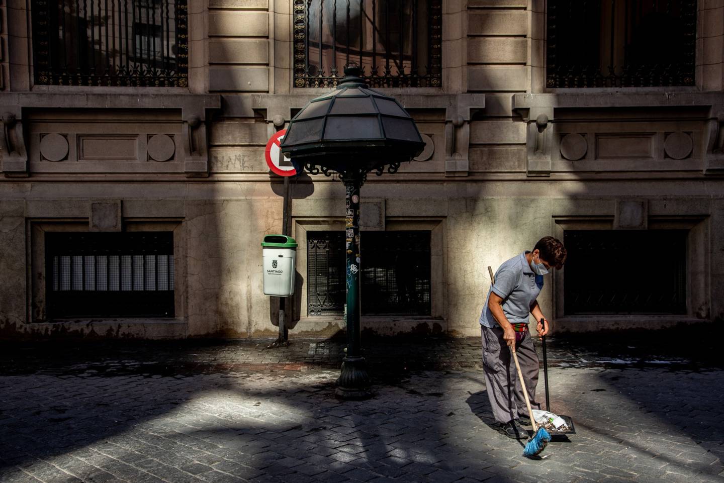 Un trabajador usa una máscara protectora mientras limpia una calle antes de una orden de cuarentena en Santiago, Chile, el jueves 26 de marzo de 2020. Fotógrafo: Cristobal Olivares/Bloomberg