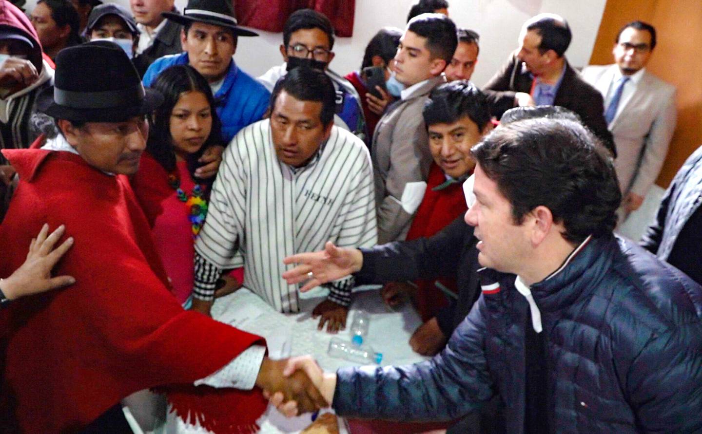 El líder indígena Leonidas Iza estrecha la mano del ministro de Gobierno, Francisco Jiménez, tras la firma del acuerdo.