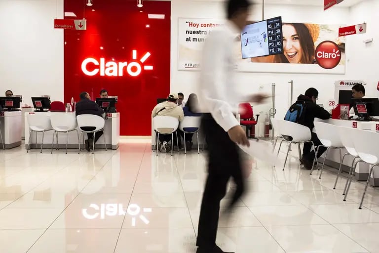 Empleados asisten a los clientes en una tienda de Claro Colombia en Bogotá.dfd