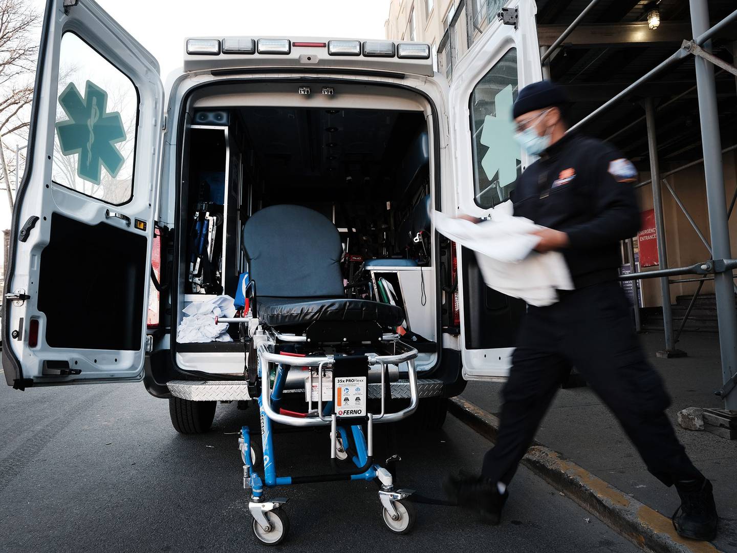 Un trabajador de emergencia limpia la camilla ante la sospecha de haber transportado a un paciente con covid afuera de un hospital en Brooklyn, el 29 de marzo 2021 en la ciudad de Nueva York.