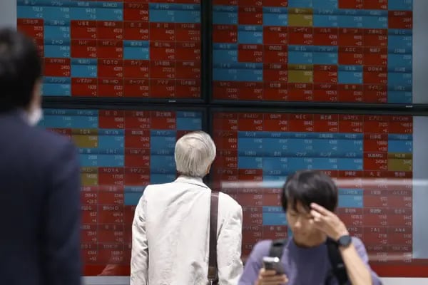 Un peatón mira una pizarra electrónica de valores fuera de una empresa de valores en Tokio, Japón, el jueves 1 de junio de 2023.