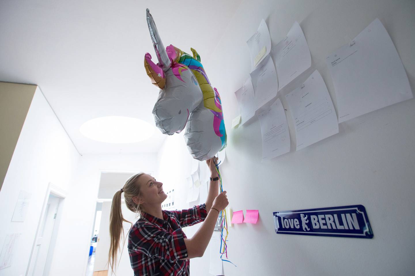 Pia Poppenreiter, cofundadora y directora ejecutiva de la aplicación de citas Ohlala, ajusta un globo de unicornio dentro del centro tecnológico Factory Berlin en Berlín, Alemania, el lunes 9 de mayo de 2016.