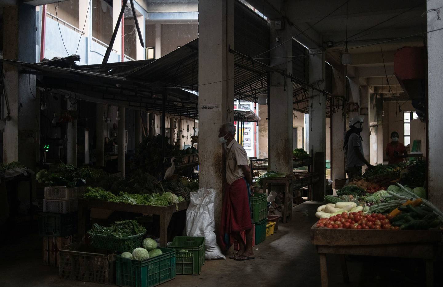 Un vendedor de frutas y verduras espera a los clientes durante un corte de luz diario en un mercado de Hikkaduwa, Sri Lanka.