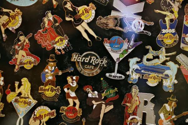 Foto com diversos broches do Hard Rock Cafe de vários lugares do mundo