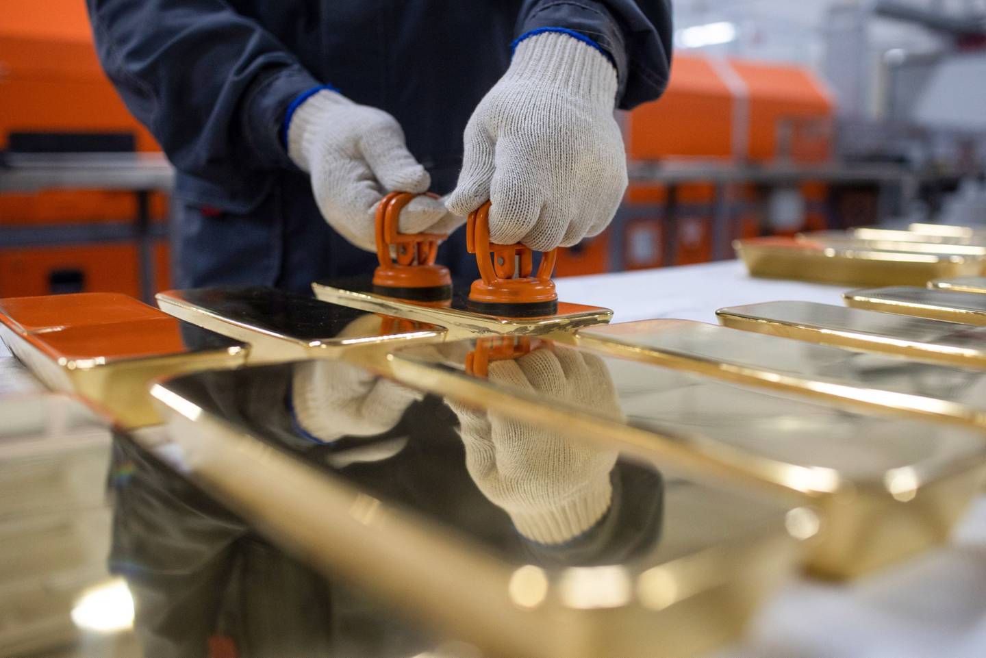 Un trabajador manipula lingotes de oro de 12 kilogramos después de la fundición automatizada en la planta de metales no ferrosos Prioksky en Kasimov, Rusia, el jueves 9 de diciembre de 2021.