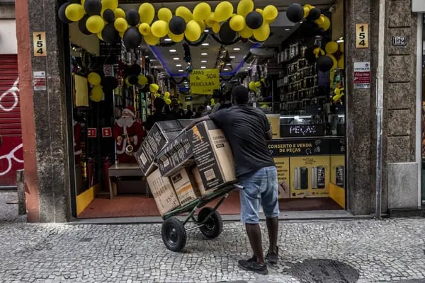 Un trabajador sostiene un carrito de productos frente a una tienda en el Viernes Negro en Río de Janeiro, Brasil, el viernes 25 de noviembre de 2022.