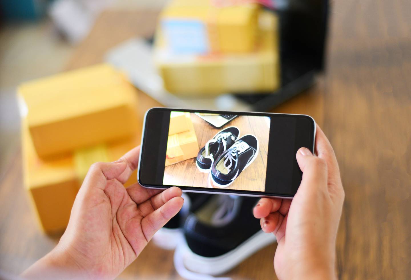 young woman taking photo sneakers with camera smartphone for post to sell online on the internet market website / selling online ecommerce shipping online shopping delivery and order conceptdfd