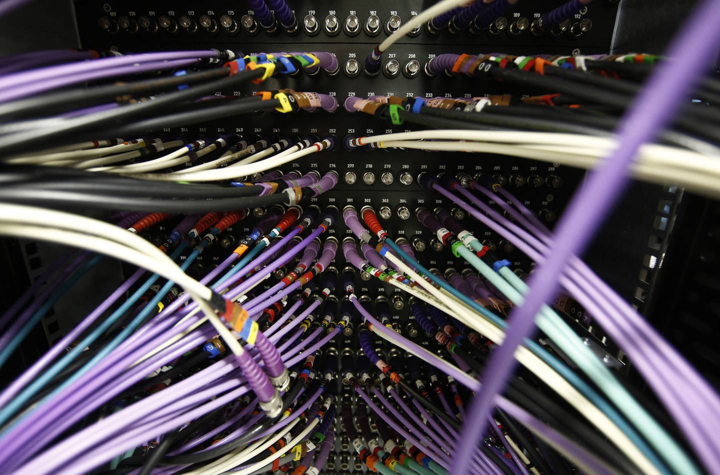 Rows of colored co-ax cables are seen feeding into computer servers inside a comms room at an office in London, U.K. Photographer: Simon Dawson/Bloomberg