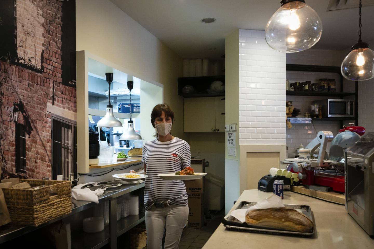 An employee wears a protective mask while serving food at a restaurant in Miami, Florida, U.S.