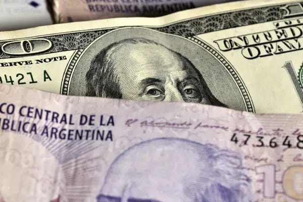 Montones de billetes de 100 pesos argentinos y 100 dólares estadounidenses se muestran para una fotografía en Buenos Aires, Argentina, el lunes 13 de diciembre de 2010. Fotógrafo: Diego Giudice/Bloomberg
