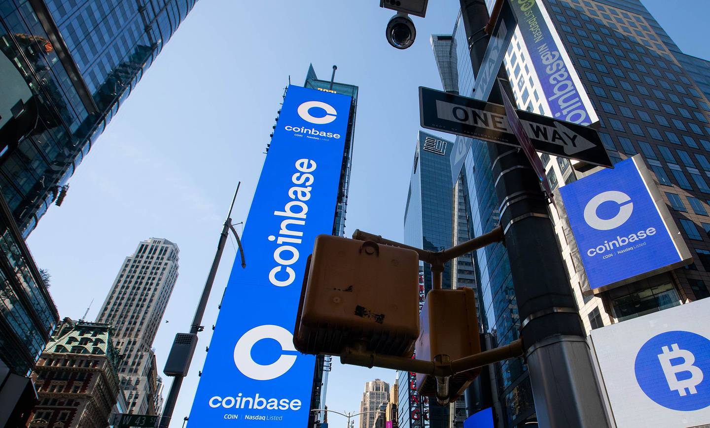 Monitores muestra el logo de Coinbase  durante su OPI en el Nasdaq MarketSite en  Nueva York.