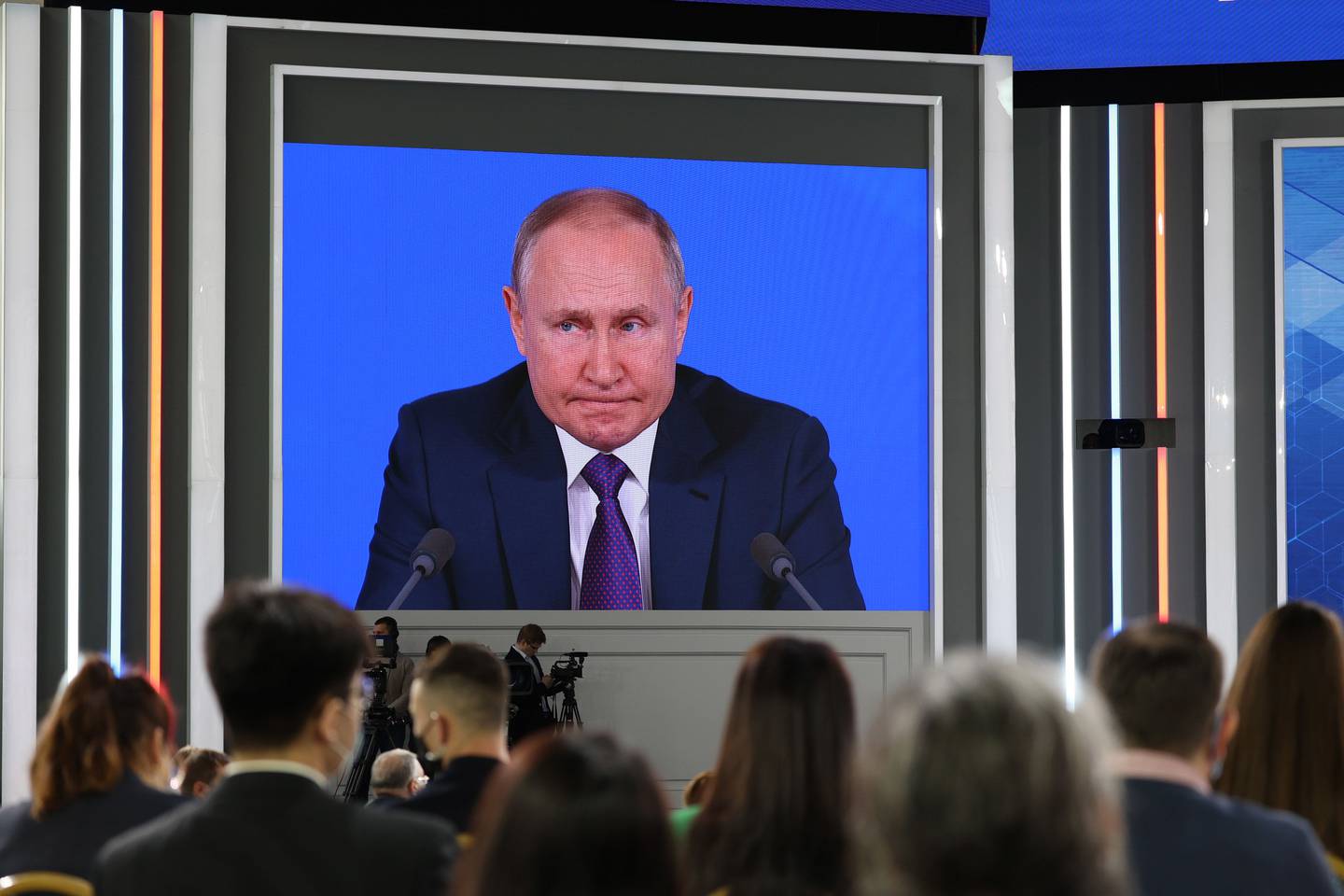 Attendees watch Vladimir Putin, Russia's President, during his annual news conference in Moscow, Russia, on Thursday, Dec. 23, 2021. Russia is continuing to build up forces close to Ukraine even as its preparing for security talks with the U.S., keeping up pressure with a deployment that could turn into a rapid invasion or a long-term threat. Photographer: Andrey Rudakov/Bloomberg