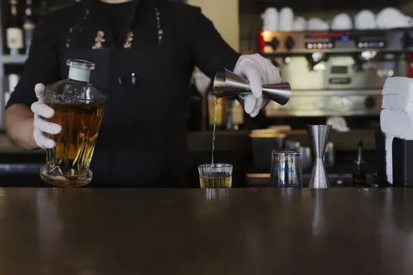 Un camarero sirve un trago de mezcal en un restaurante de Houston.