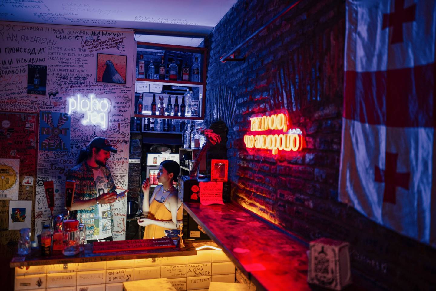 La copropietaria Dariya Zheniskhan con un camarero en su bar, Ploho, en Tiflis (Georgia), donde las paredes están adornadas con grafitis contra Putin. Fotógrafo: Tako Robakidze/Bloombergdfd