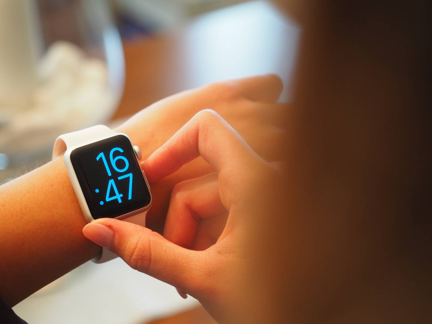 Una mujer ajusta la hora de un reloj digital de la marca Apple. (Foto: Pexels).