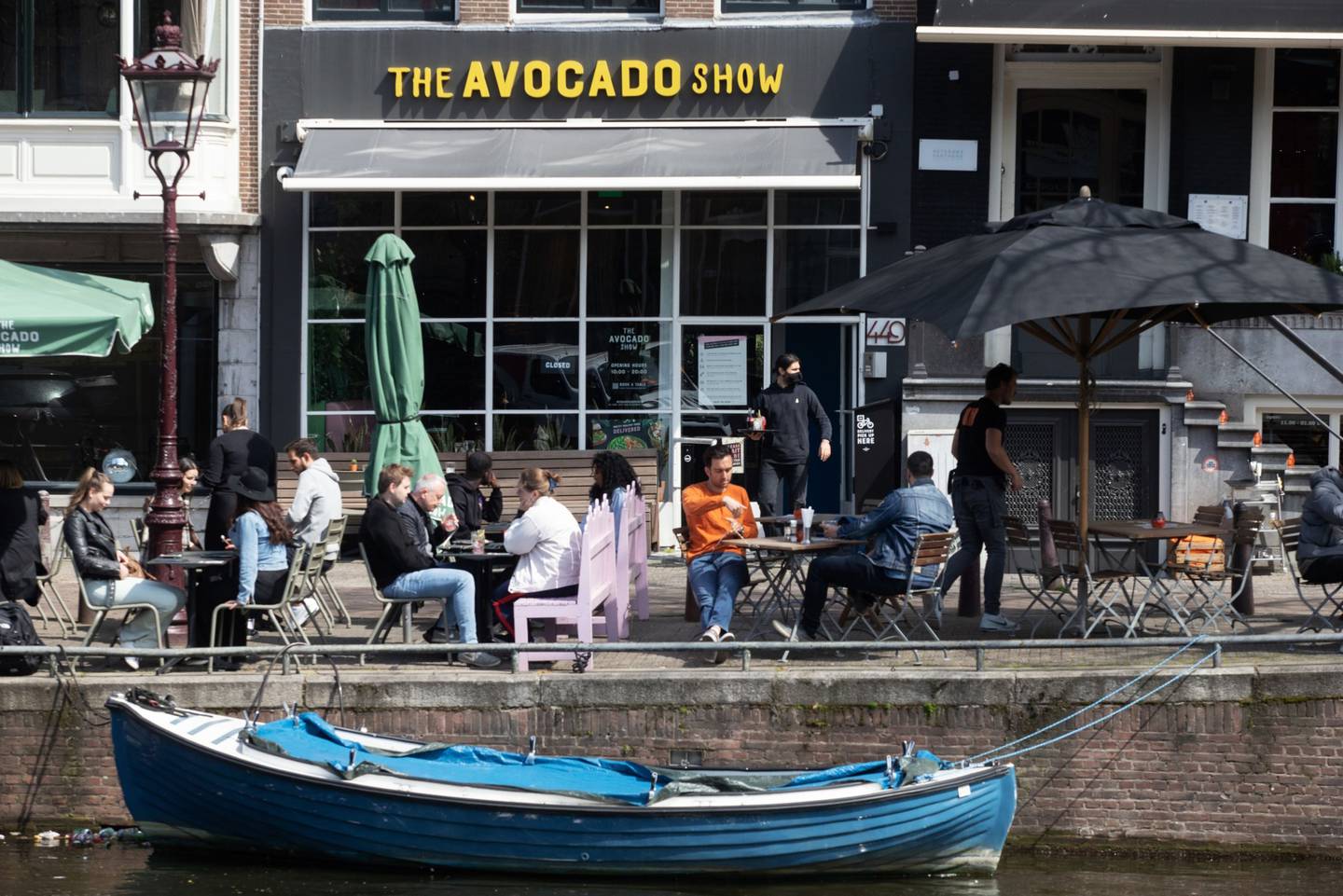 Clientes cenan en las terrazas laterales de un restaurante en Amsterdam Fotógrafo: Peter Boer/Bloombergdfd
