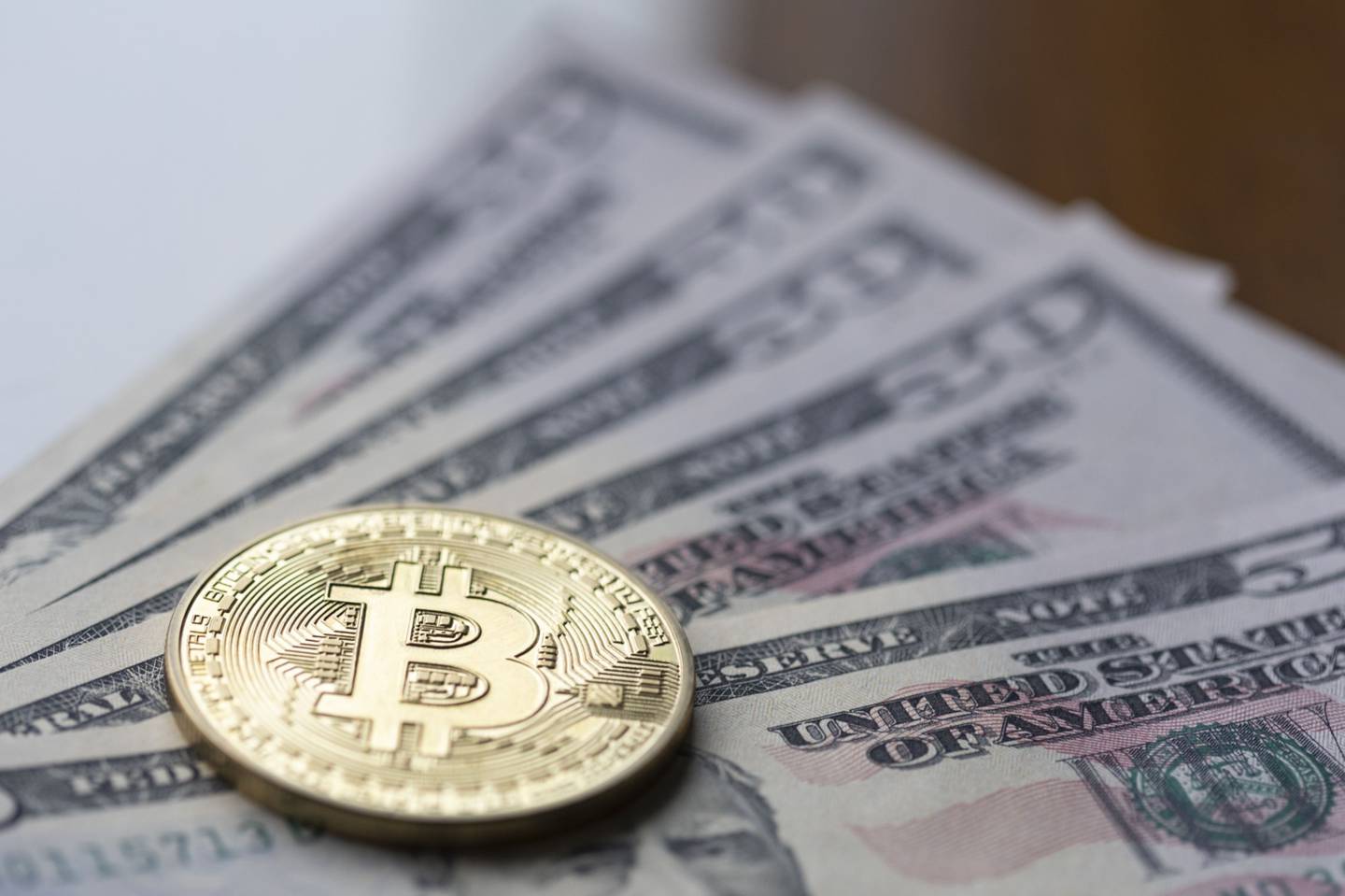 Token de bitcoin sobre billetes de dólares estadounidenses