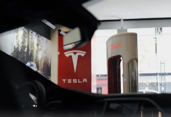 Un empleado se encuentra junto a una estación de carga mientras espera a los clientes en la tienda de Tesla Motors Inc. en San José, California.