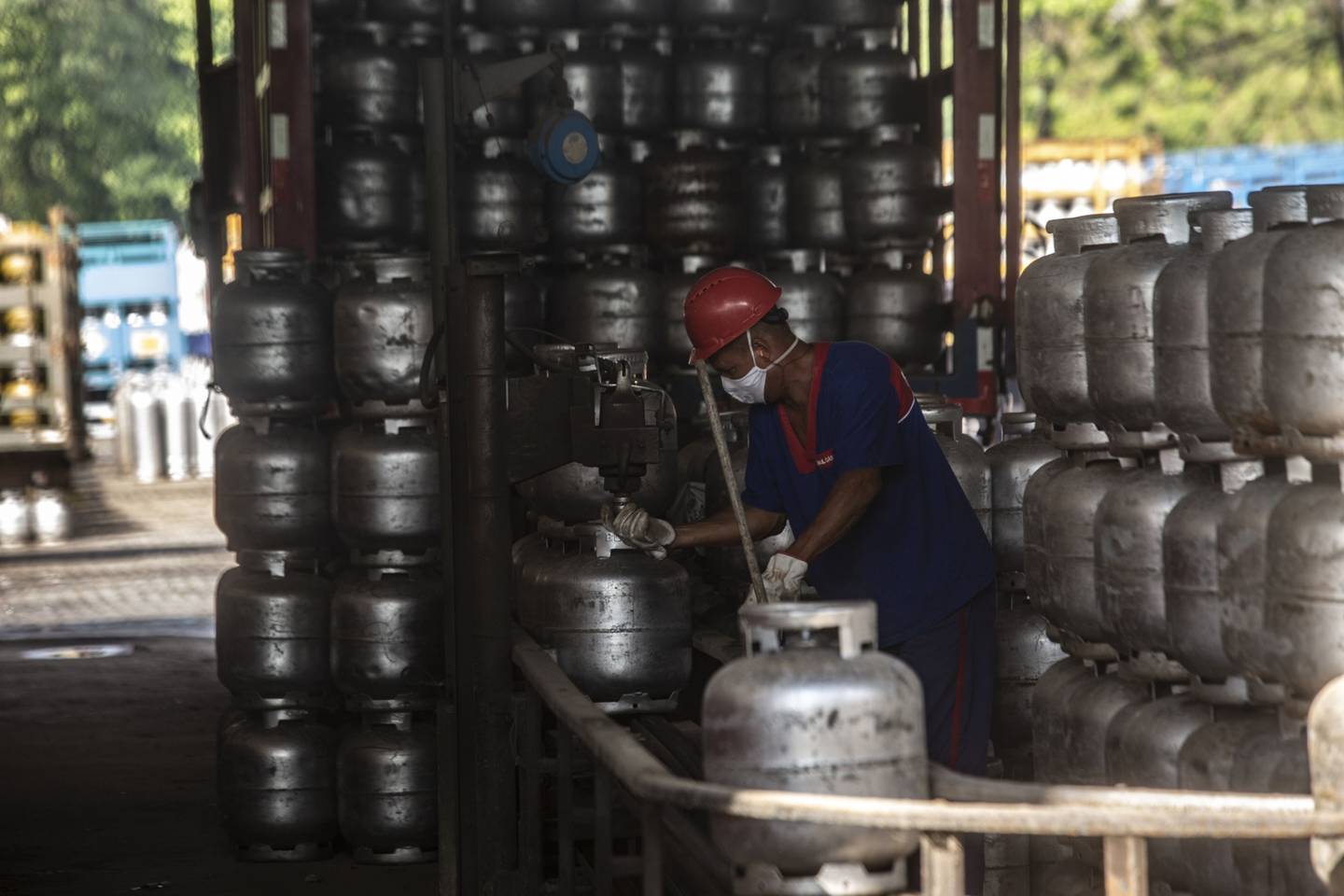 A worker loads cooking gas canisters onto a delivery truck near the Petroleo Brasileiro SA (Petrobras) Duque de Caxias Refinery (Reduc) refinery in Duque de Caxias, Rio de Janeiro state, Brazil, on Monday, Oct. 4, 2021.dfd