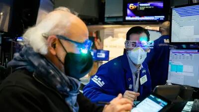 Traders wear "2022" glasses while working on the floor of the New York Stock Exchange (NYSE) in New York, U.S., on Friday, Dec. 31, 2021. U.S. stocks swung between gains and losses, with moves exacerbated by thin trading on the last session of the year. Photographer: Michael Nagle/Bloomberg