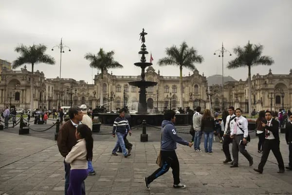 La gente camina fuera del Palacio de Gobierno en la Plaza de Armas en Lima, Perú.