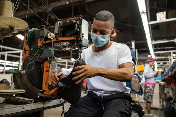 Un trabajador cose la suela de un zapato en la planta de producción de la fábrica de calzado Calzado Rómulo en Yumbo, departamento del Valle del Cauca, Colombia, el viernes 10 de marzo de 2023.