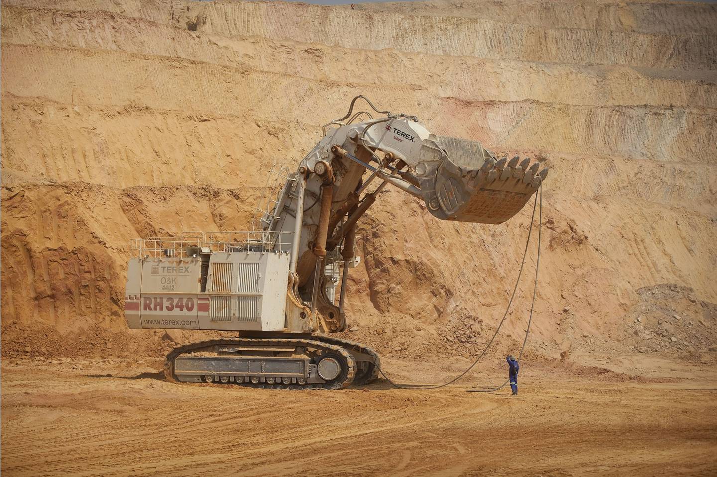 Un trabajador ayuda a operar una excavadora minera gigante de Terex Corp. durante la extracción de mineral del pozo abierto en la mina de cobre y cobalto KOV de Katanga Mining Ltd. en Kolwezi, provincia de Katanga, República Democrática del Congo, el miércoles 1 de agosto de 2012.