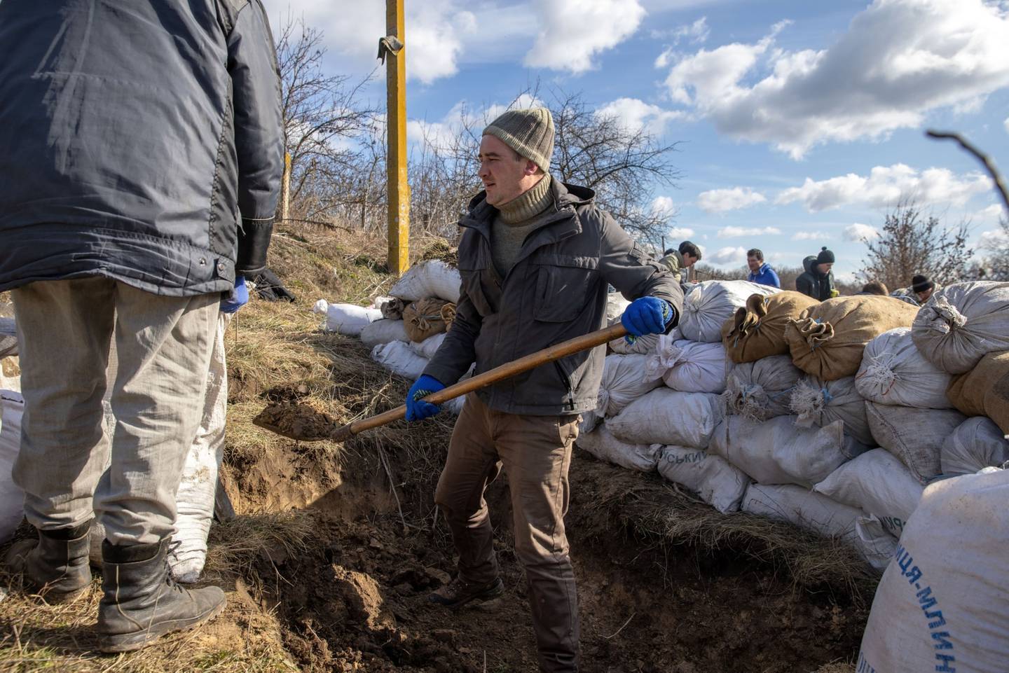 Aldeanos llenan sacos de tierra mientras preparan fortificaciones contra el ejército ruso en una carretera entre Kaharlyk y Zhytomyr, en el suroeste de Ucrania, el sábado 26 de febrero de 2022.