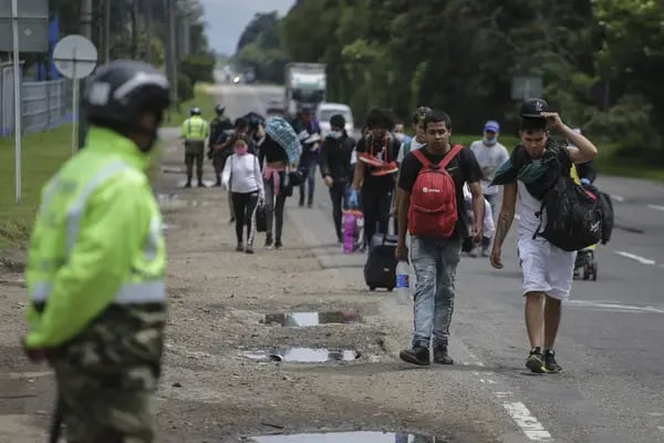 Migrantes venezolanos caminan al costado de una carretera hacia un puesto de control militar en su camino de regreso a Venezuela en Bogotá, Colombia, el viernes 3 de abril de 2020.