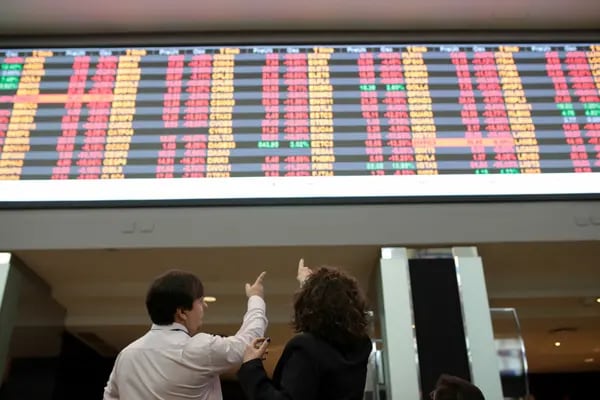 Visitors point towards the electronic board displaying stock activity at the Brasil Bolsa Bacao (B3) stock exchange. Photographer: Patricia Monteiro/Bloomberg