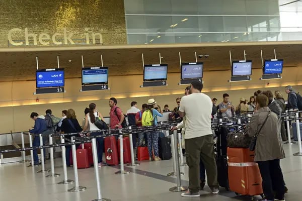 Viajeros hacen cola para facturar en el aeropuerto El Dorado de Bogotá.