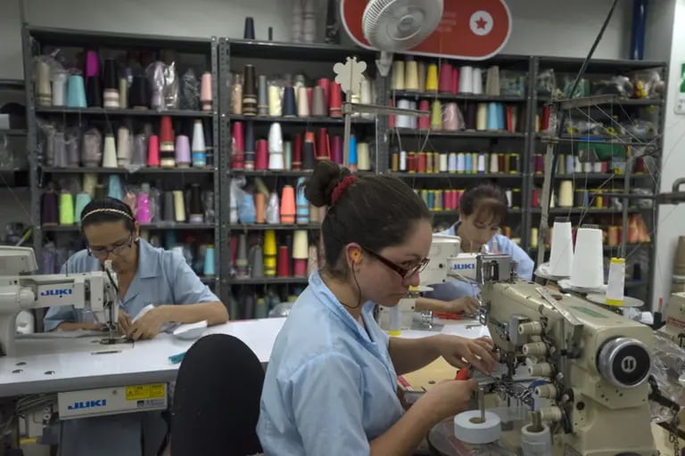 Los trabajadores operan máquinas de coser en una fábrica en Medellín, Colombia, el lunes 25 de agosto de 2014.dfd