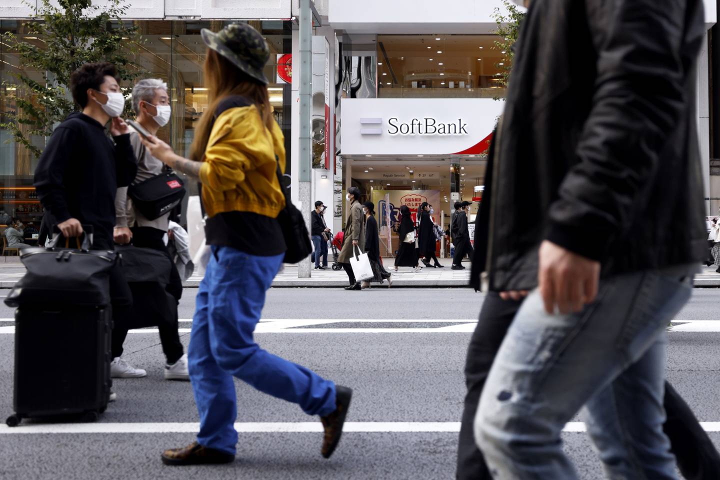Pedestrians in front of a SoftBank Corp. store in Tokyo, Japan, on Sunday, Nov. 7, 2021.