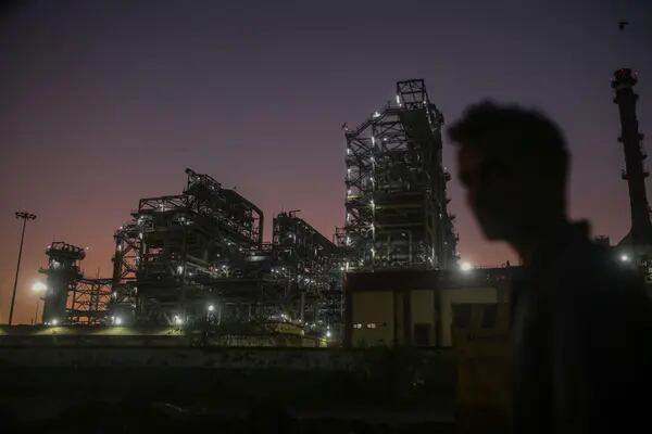 Un peatón pasa por delante de una refinería de petróleo, operada por Bharat Petroleum Corp. Ltd., en Mumbai, India, el sábado 10 de diciembre de 2022. Fotógrafo: Dhiraj Singh/Bloomberg