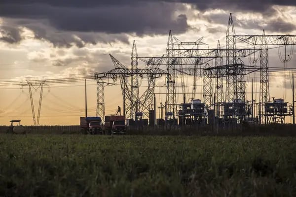 Electricity transmission towers stand past a farm in Rosario, Bahia.