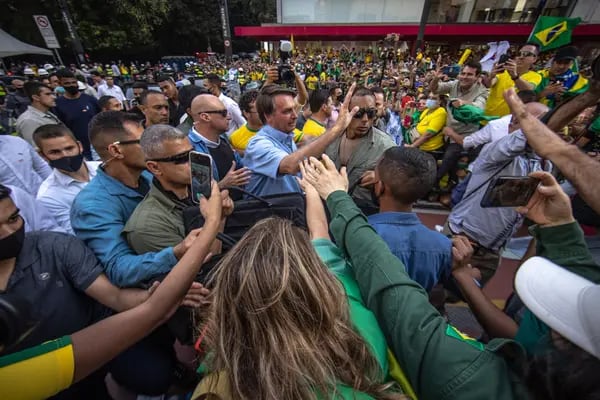 El presidente brasileño Jair Bolsonaro saluda a seguidores.