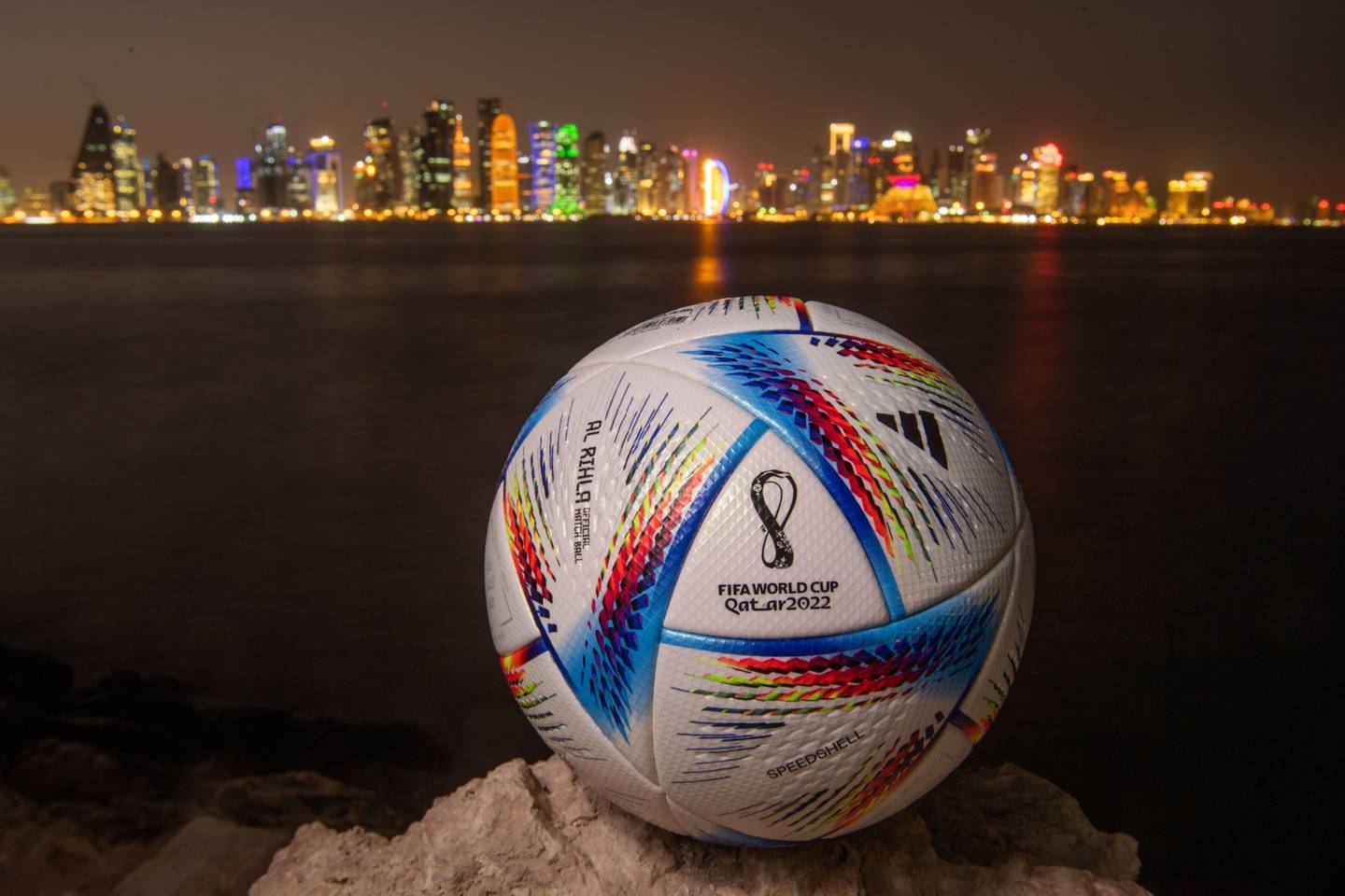 In this photo, an official FIFA World Cup Qatar 2022 ball sits on display in front of the skyline of Doha.