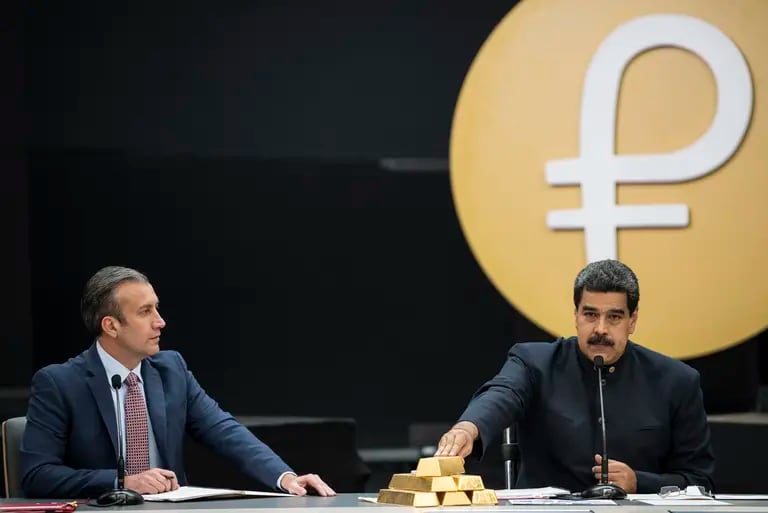 Nicolás Maduro, a la derecha, habla mientras toca una pila de lingotes de oro de 12 kilogramos durante una conferencia de prensa sobre la criptomoneda del país en 2018.Fotógrafo: Carlos Becerra/Bloombergdfd