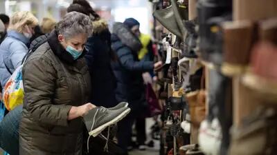 Ucranianos deslocados coletam itens no ‘Wardrobe of Good’, uma iniciativa que oferece roupas gratuitas, em Cracóvia, em 14 de março.