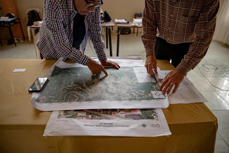 Iván Núñez, a la izquierda, traza estudios de suelo y ubicaciones de túneles ilegales, en Zaruma.dfd