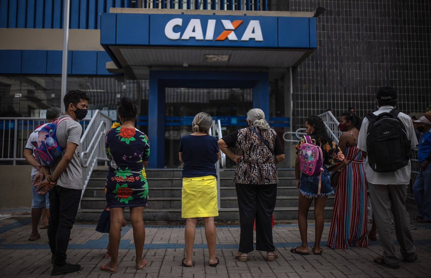 People line up in front of a bank to receive government aid in Juazeiro do Norte, Ceara state. Photographer: Jonne Roriz/Bloombergdfd