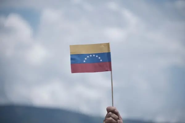 Un asistente sostiene una bandera venezolana durante la reapertura de la frontera comercial entre Venezuela y Colombia en Cúcuta, departamento de Norte de Santander, Colombia, el lunes 26 de septiembre de 2022.